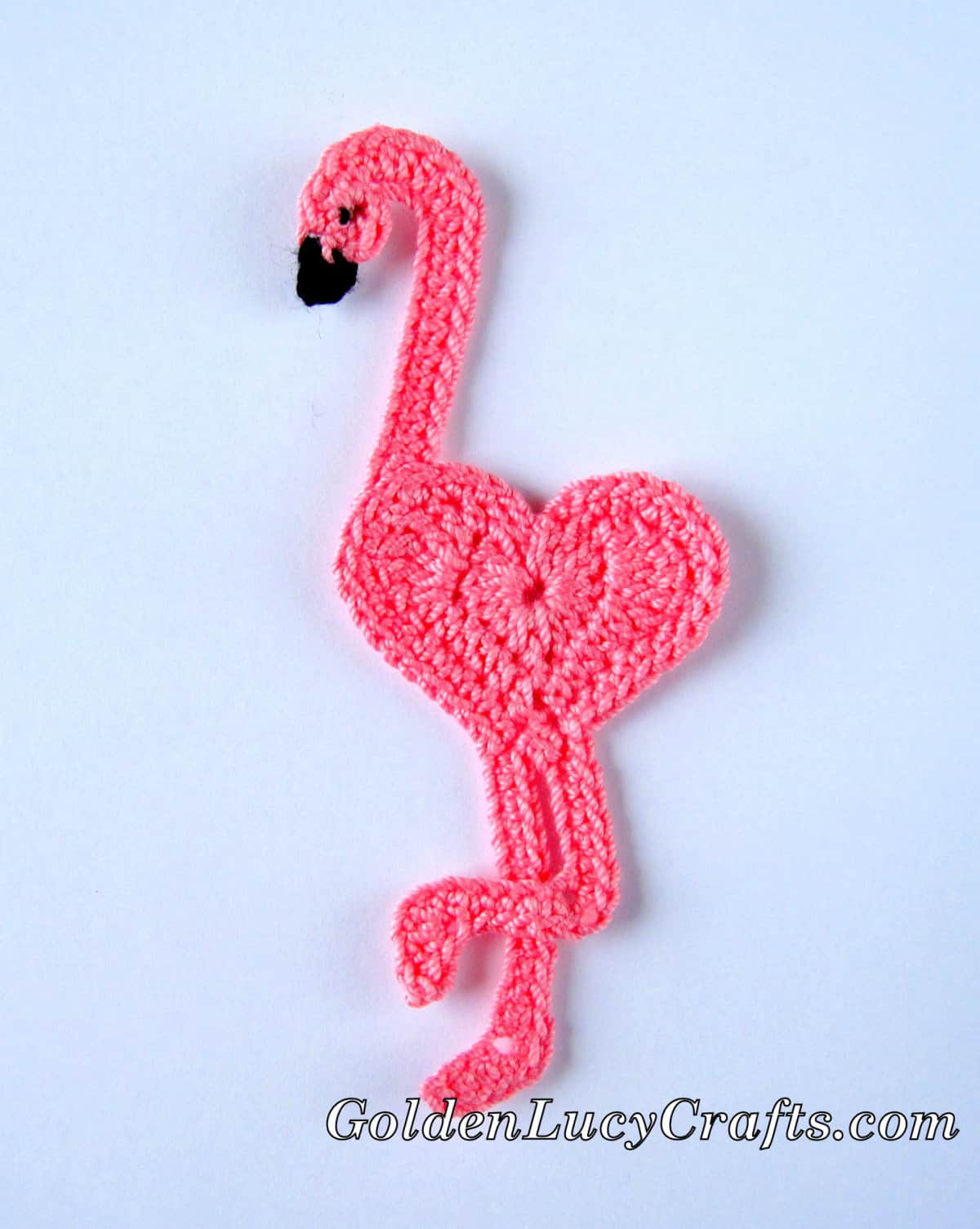 Crocheted pink heart-shaped flamingo applique.