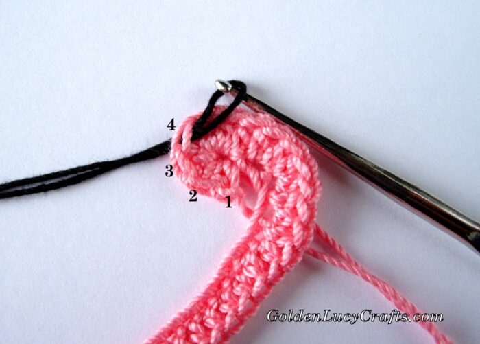 Process shot of crocheting flamingo applique.