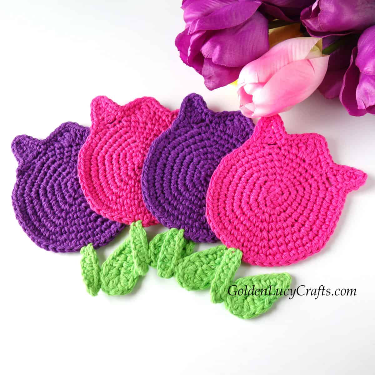 Crocheted tulip coasters in pink and purple colors.