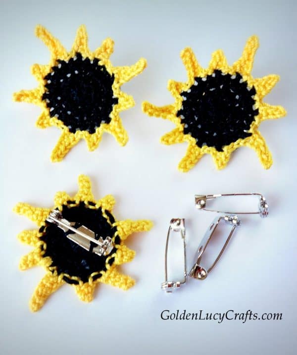 Three pins for total solar eclipse made from crochet appliques.