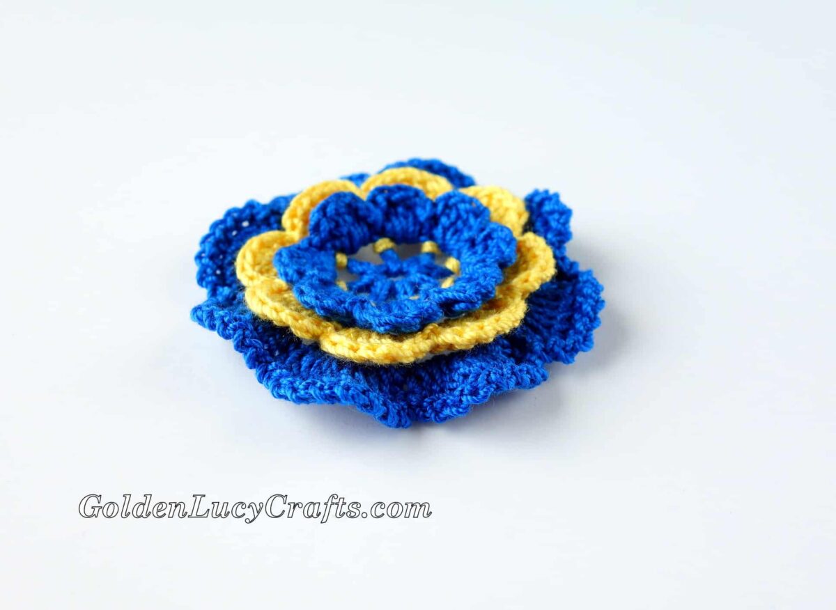 Crocheted flower Irish Rose in blue and yellow.