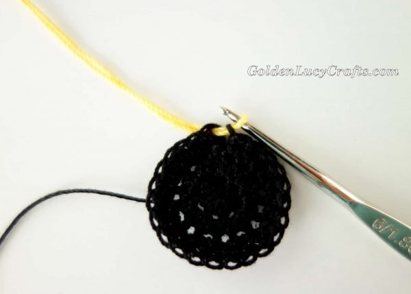 Joining yellow color to the crocheted black circle.