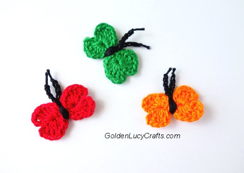 Three tiny crocheted butterflies.