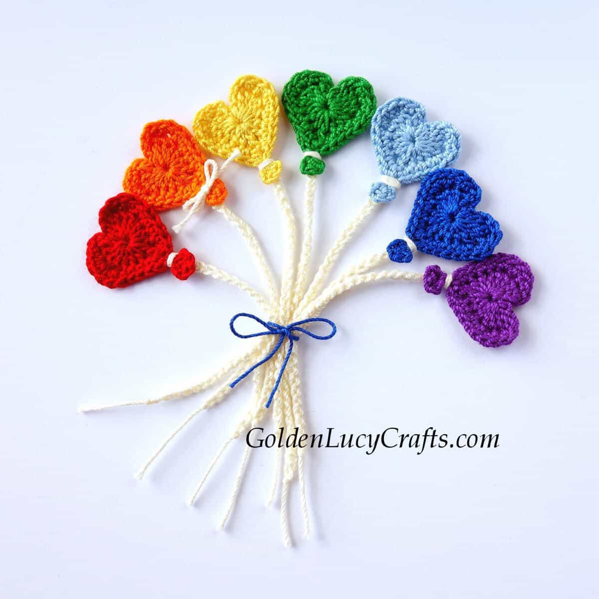 Bunch of crocheted heart-shaped balloons in colors of rainbow.