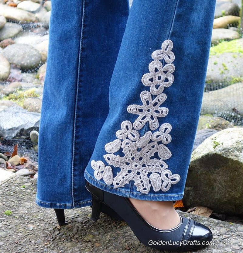 Jeans embellished with crochet appliques.