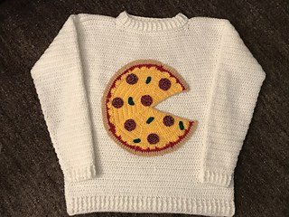 Crocheted sweater embellished with pizza applique.