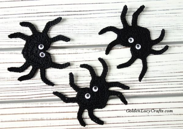 Three black crocheted spiders.