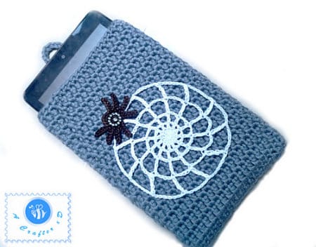 Smart phone in crocheted case embellished with spider and spider web appliques.