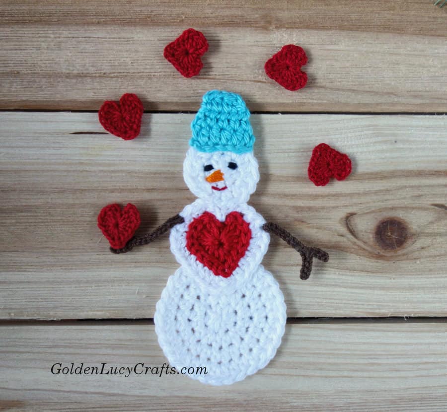 Snowman juggling with red hearts crochet applique.