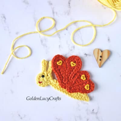 Crochet butterfly applique in yellow and brown color with heart-shaped wings.