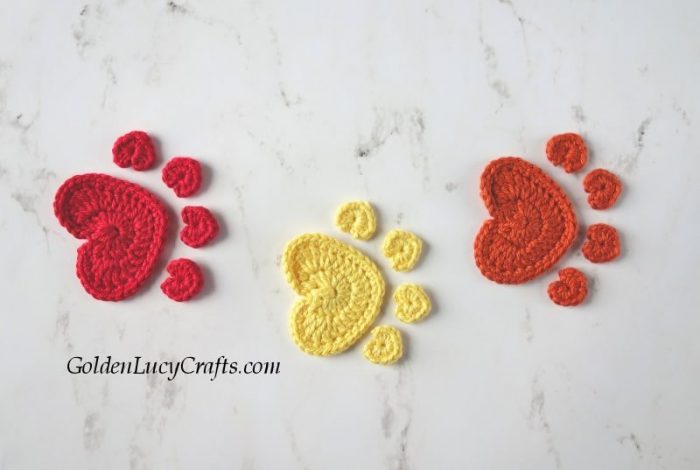 Three crochet paw print appliques.