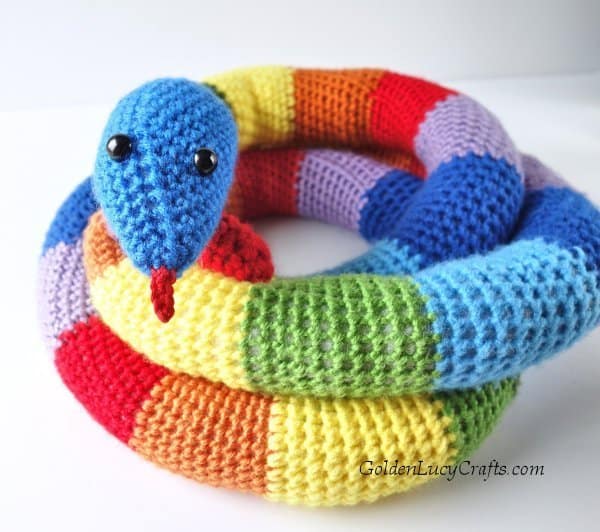 Crochet rainbow snake facing you.