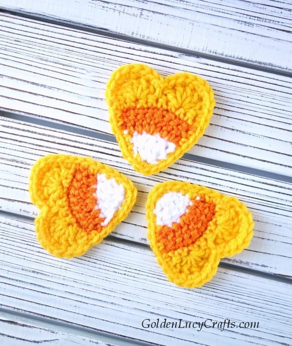 Three heart-shaped crochet candy corn appliques.