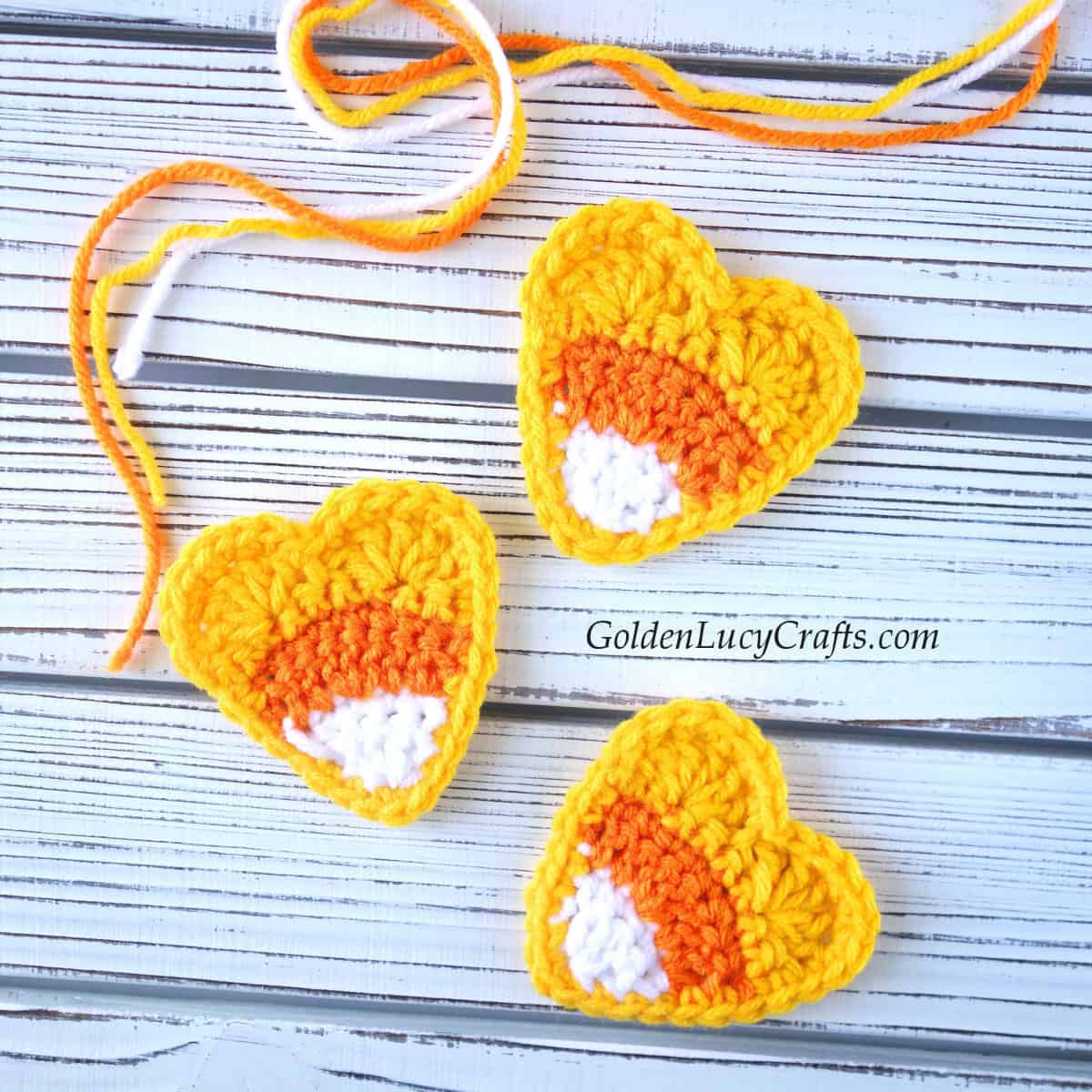 Three crocheted candy corn heart appliques.