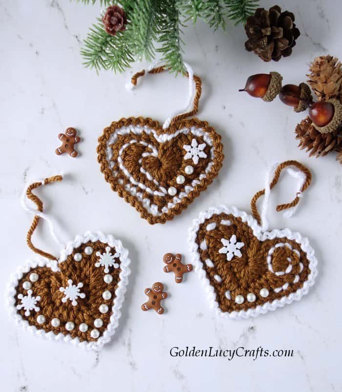 Three crocheted gingerbread heart ornaments.