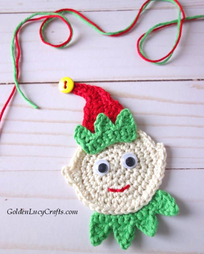 Crocheted elf applique, red and green yarn.