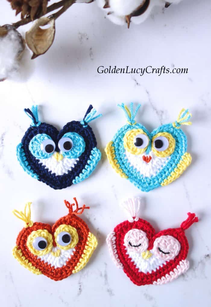 Four crocheted heart owl appliques.
