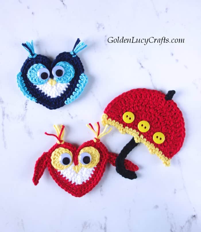 Two crochet owl appliques, one of them is holding an umblella.