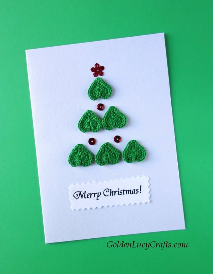 Diy Christmas card, Christmas tree made from crocheted hearts and sequins on it, text saying Merry Christmas.