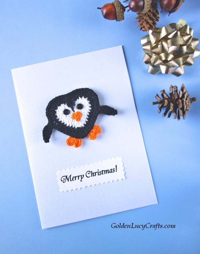 Handmade Christmas card embellished with crochet penguin applique, text saying Merry Christmas.