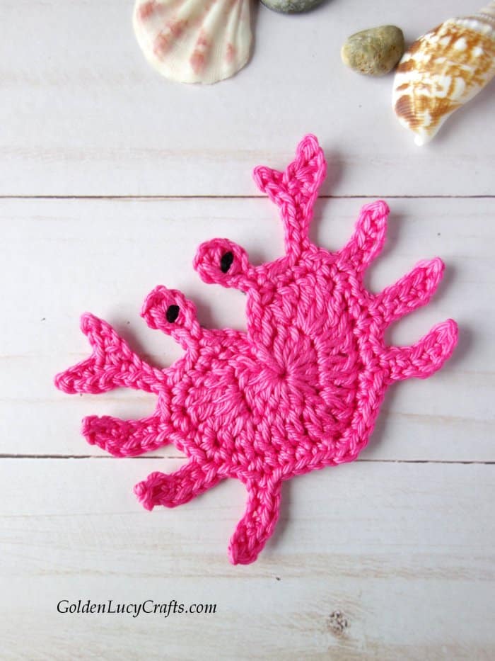 Crocheted pink heart-shaped crab applique.