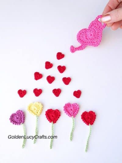 Crocheted flowers, hearts and watering can.