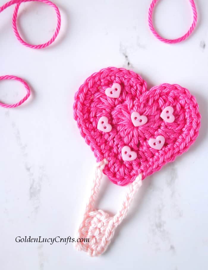 Crochet heart hot air balloon applique embellished with tiny heart-shaped buttons.