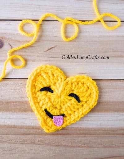 Crochet emoji face savoring food.
