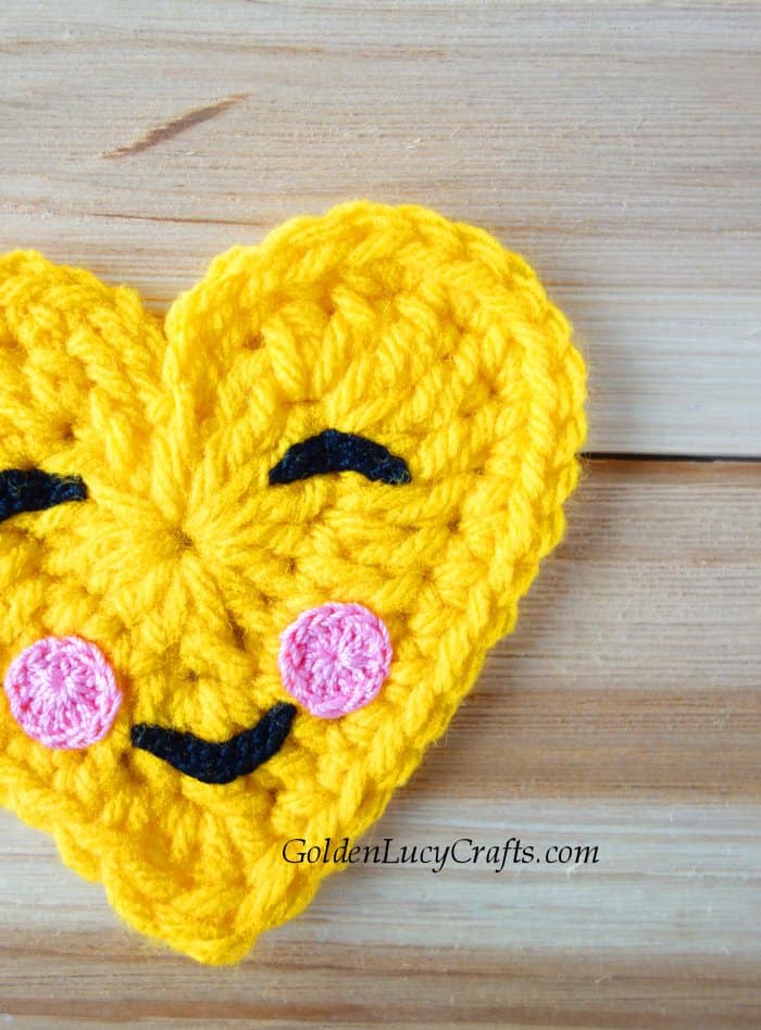 Crochet happy face emoji close up picture.