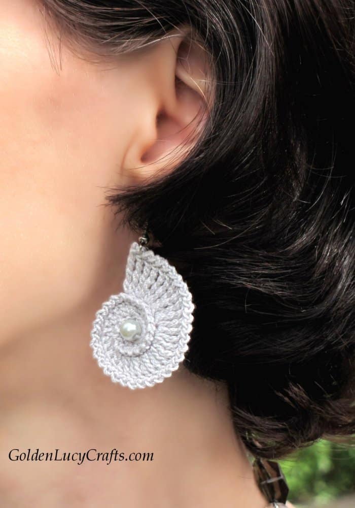 Model is wearing crochet seashell earrings in grey color