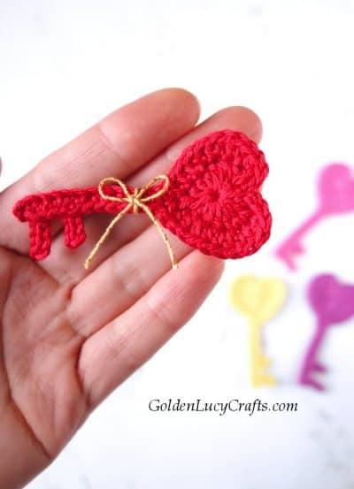 Crochet applique Key to My Heart in the palm of a hand.