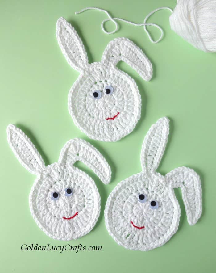Three white crocheted eggs with bunny ears.