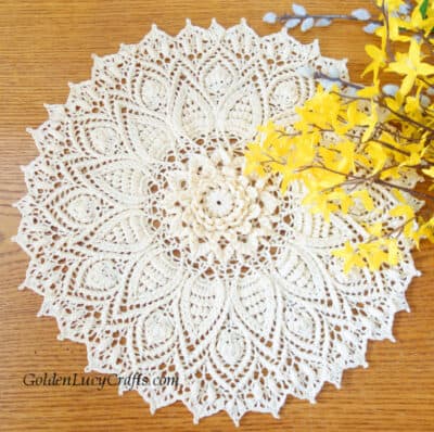 Crocheted doily and yellow flowers.