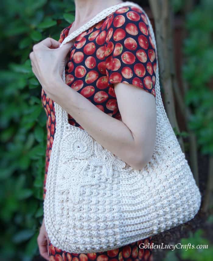 Model is wearing on her shoulder crocheted handbag