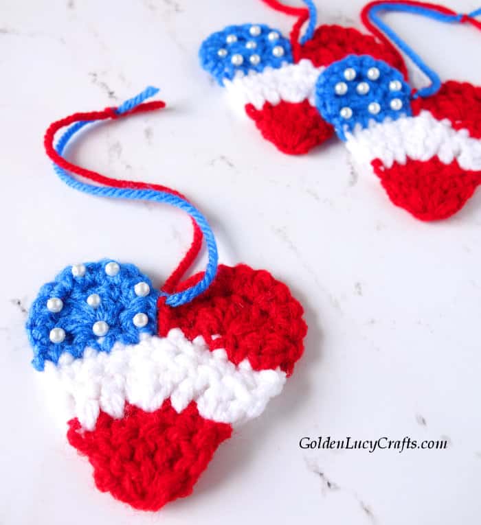 Crochet patriotic heart in red, white and blue colors, close up image.