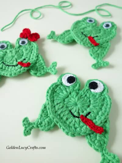 Crocheted green frog appliques.