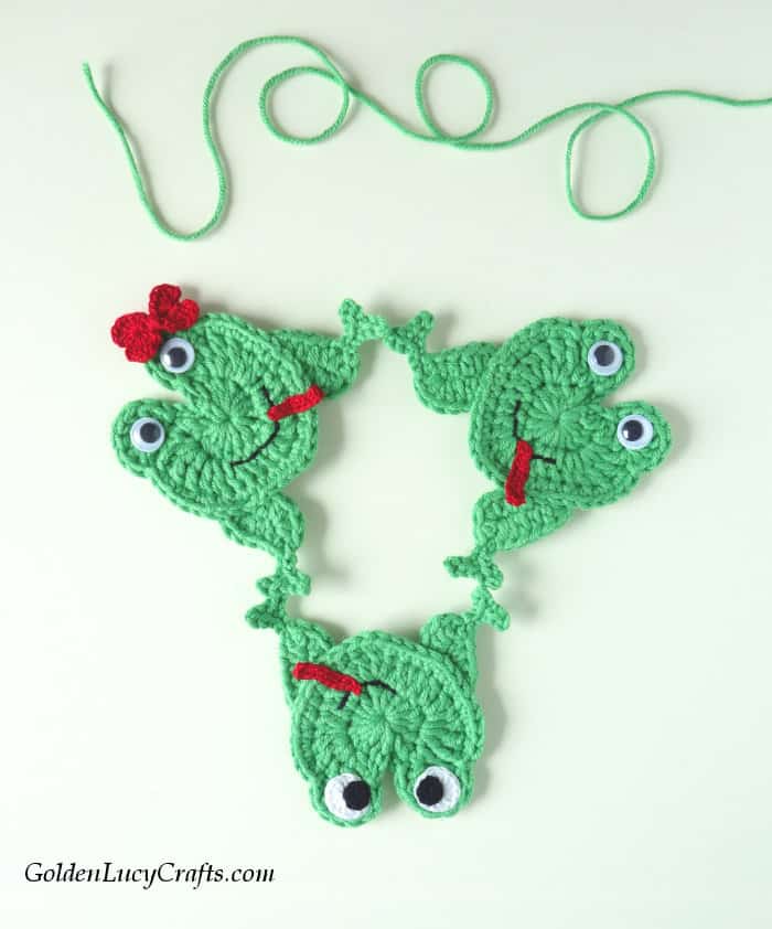 Three crocheted frogs