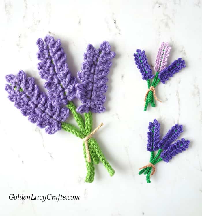 Three bundles of crocheted lavender made from different yarn.