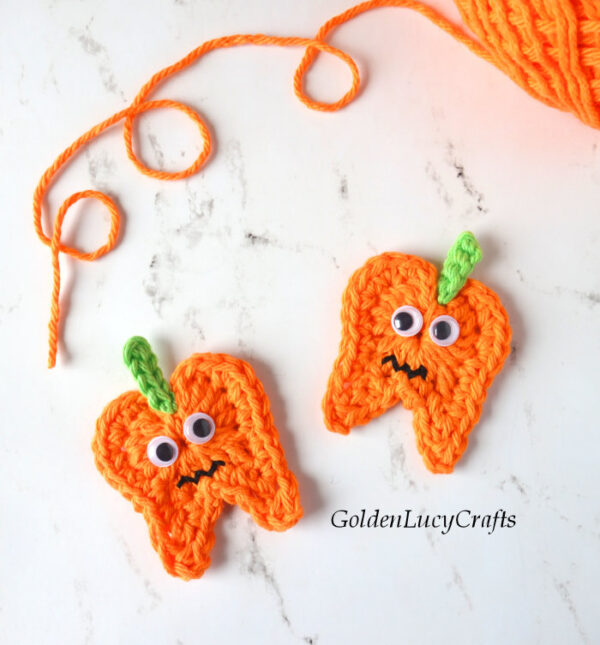 Two crocheted tooth pumpkin appliques.