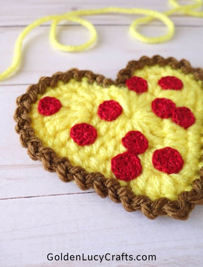 Crochet heart-shaped pizza close up picture.