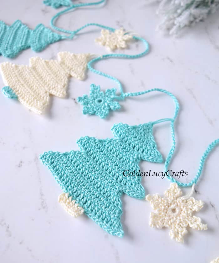 Crochet Christmas tree garland in turquois and cream, close up image