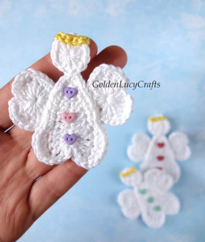 Crochet heart angel applique in the palm of a hand.