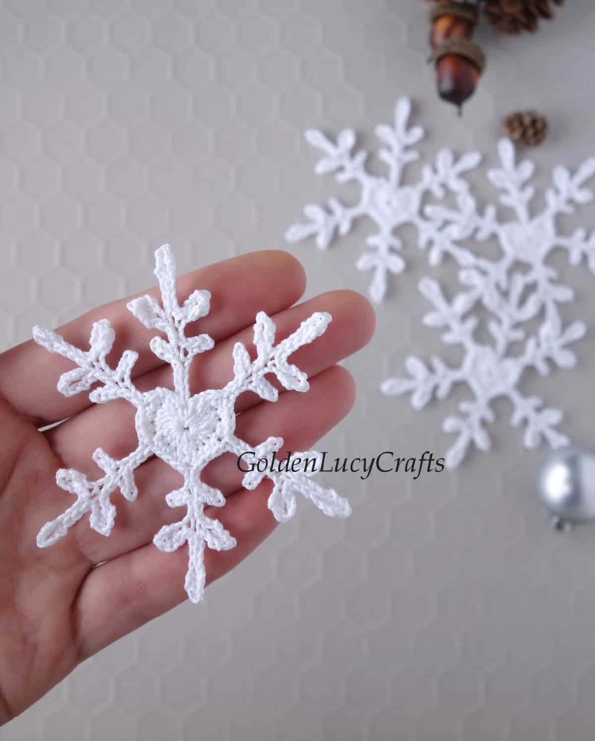 Crochet snowflake in the palm of a hand.
