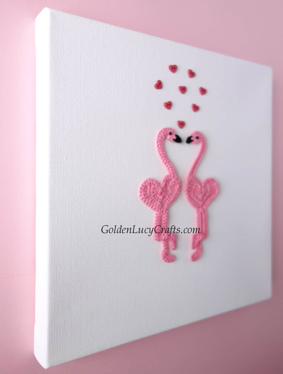 Valentine's Day wall art - two crocheted flamingo applique, side view.