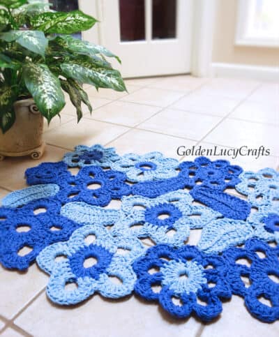 Crochet flower rug laying on the tile floor.