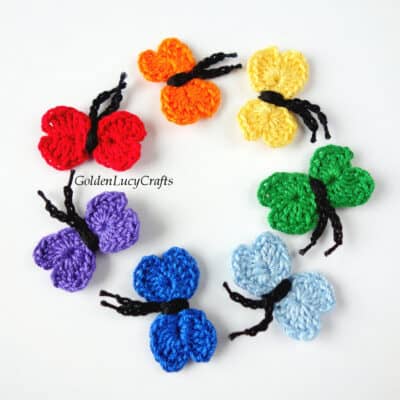 Crochet small butterflies in rainbow colors.