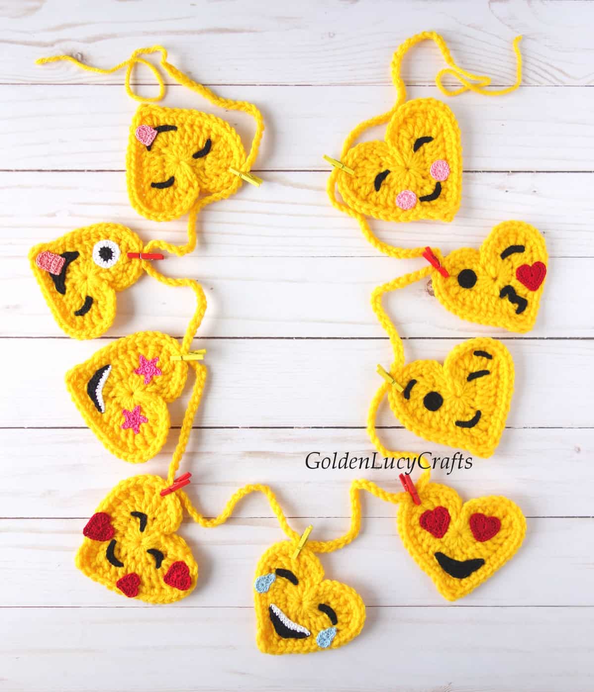 Handmade garland made from crocheted heart-shaped emojis.