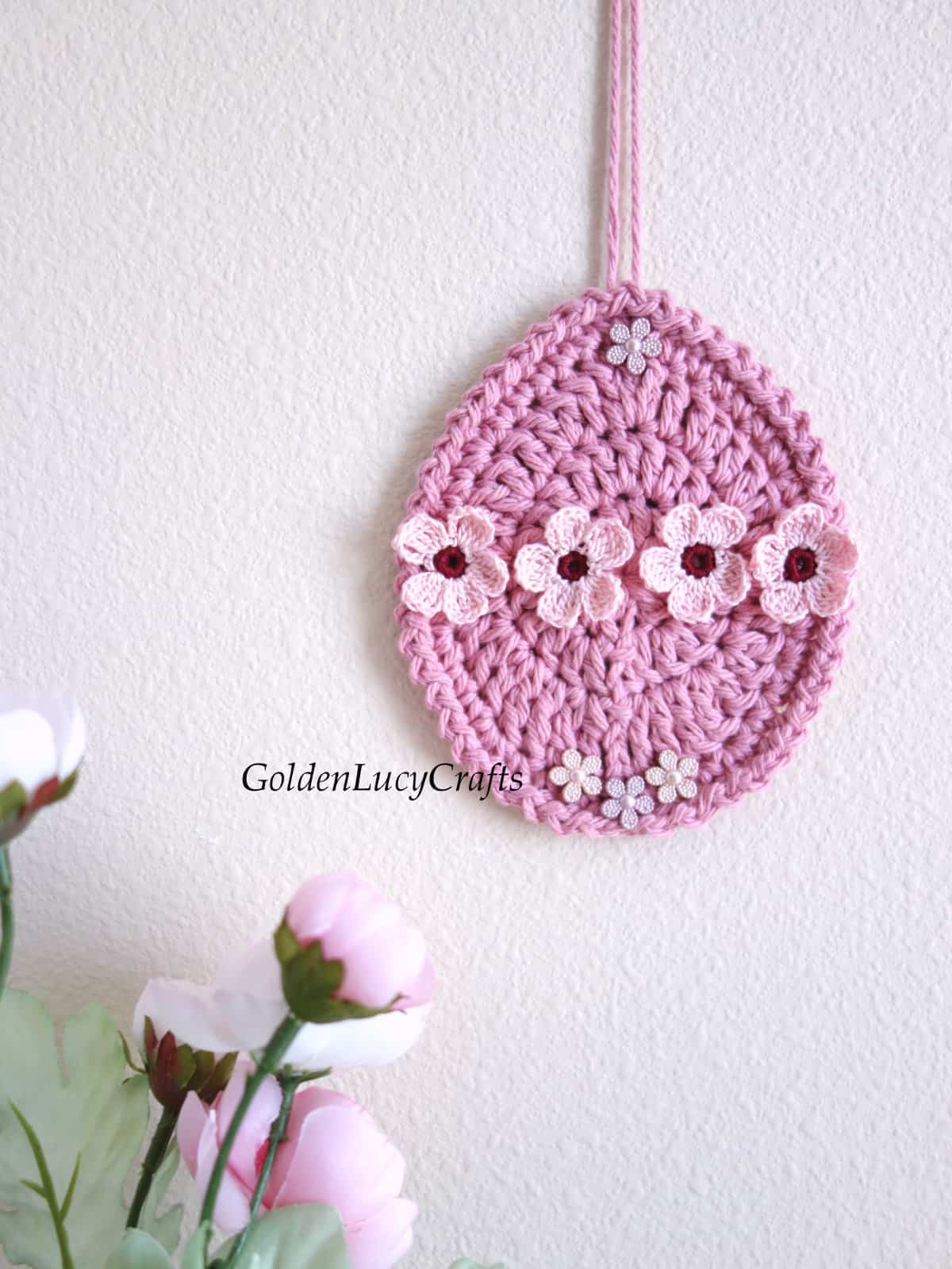 Crochet Easter egg ornament hanging on the wall.