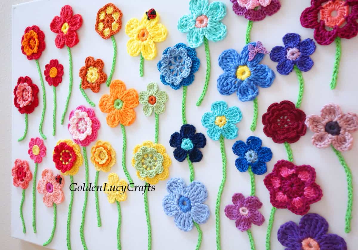 Crochet flowers on canvas wall art, side view.