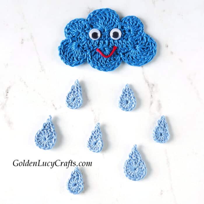 Crocheted cloud with googly eyes and smile, raindrops applique.